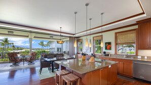 Cozinha espaçosa com uma ilha grande, armários de madeira e vista para o exterior.