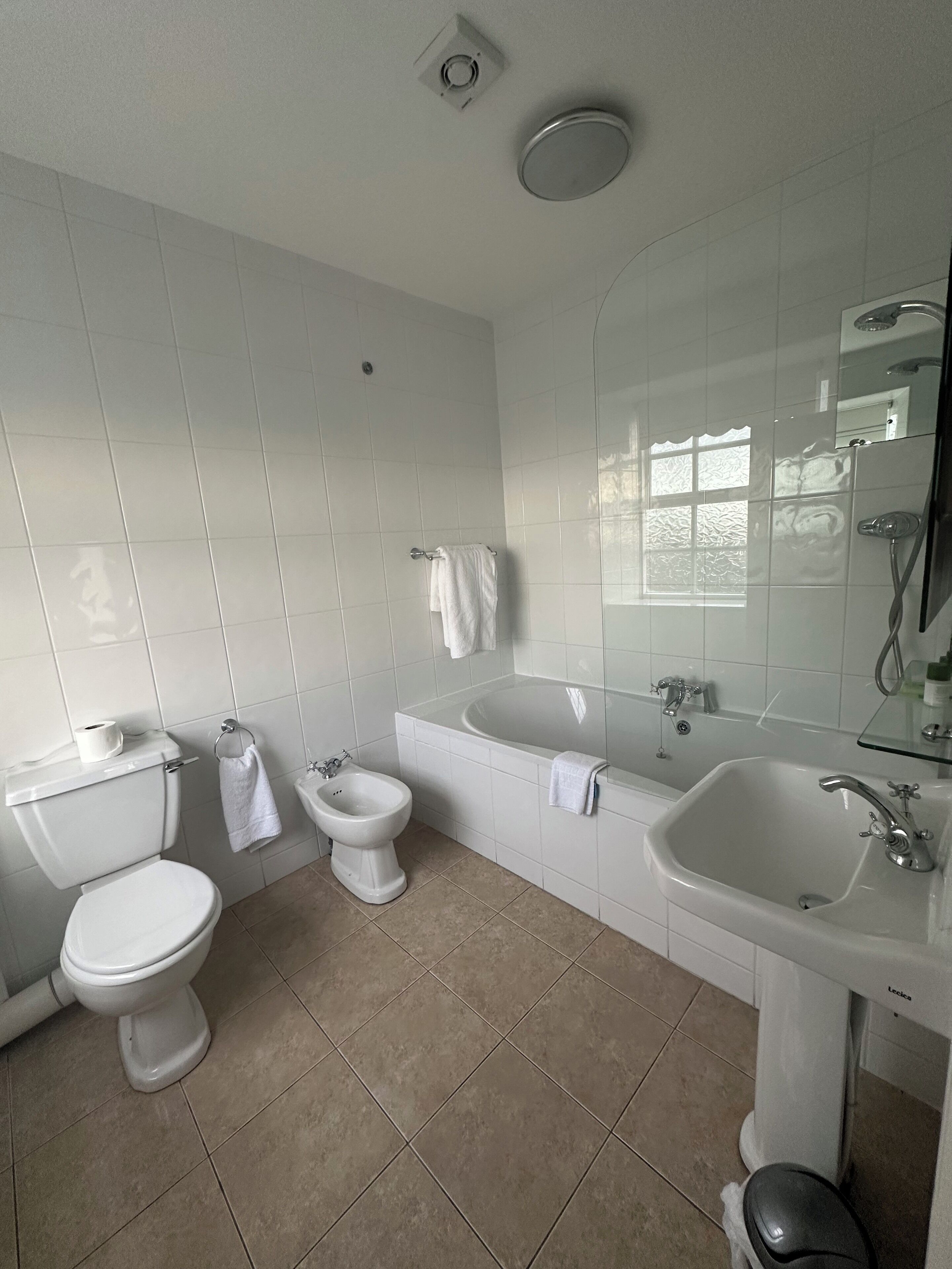 Un baño con inodoro, bidé, bañera y lavamanos.