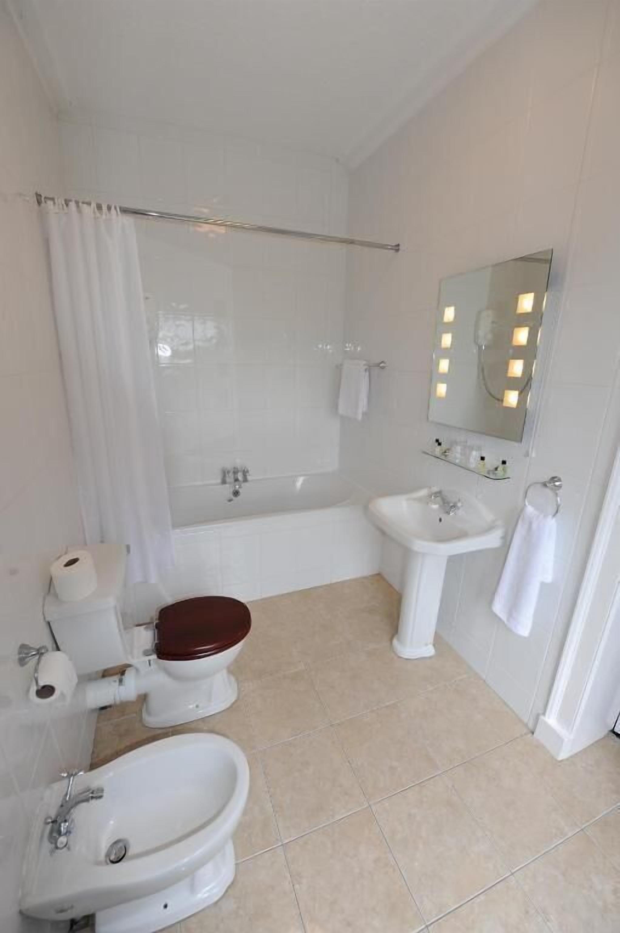 A bathroom with a bathtub, a sink, a toilet, and a bidet.