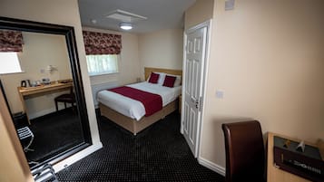 Une chambre d’hôtel comprenant un lit, un bureau, une chaise, une armoire et une salle de bain.