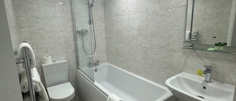 A modern bathroom with a bathtub, toilet, and sink.