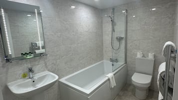 A modern bathroom with a sink, bathtub, toilet, and a glass shower enclosure.