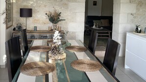 A dining area with a long table, chairs, and a hanging light fixture. - Le Petit Chai Fronsadais - Gite *** 5 persons (Saint-Michel-de-Fronsac)