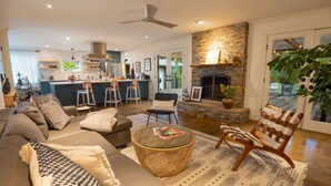Uma sala de estar moderna com sofá, poltronas, mesa de centro e lareira.