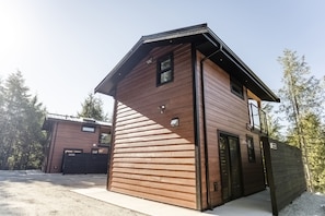 A modern two-story building with a sloped roof and a wooden exterior.