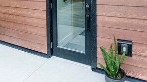 A modern building with a wooden facade and a glass door. - Sitka Cabin-Modern, Hikes, OD shower, Pet (Ucluelet)
