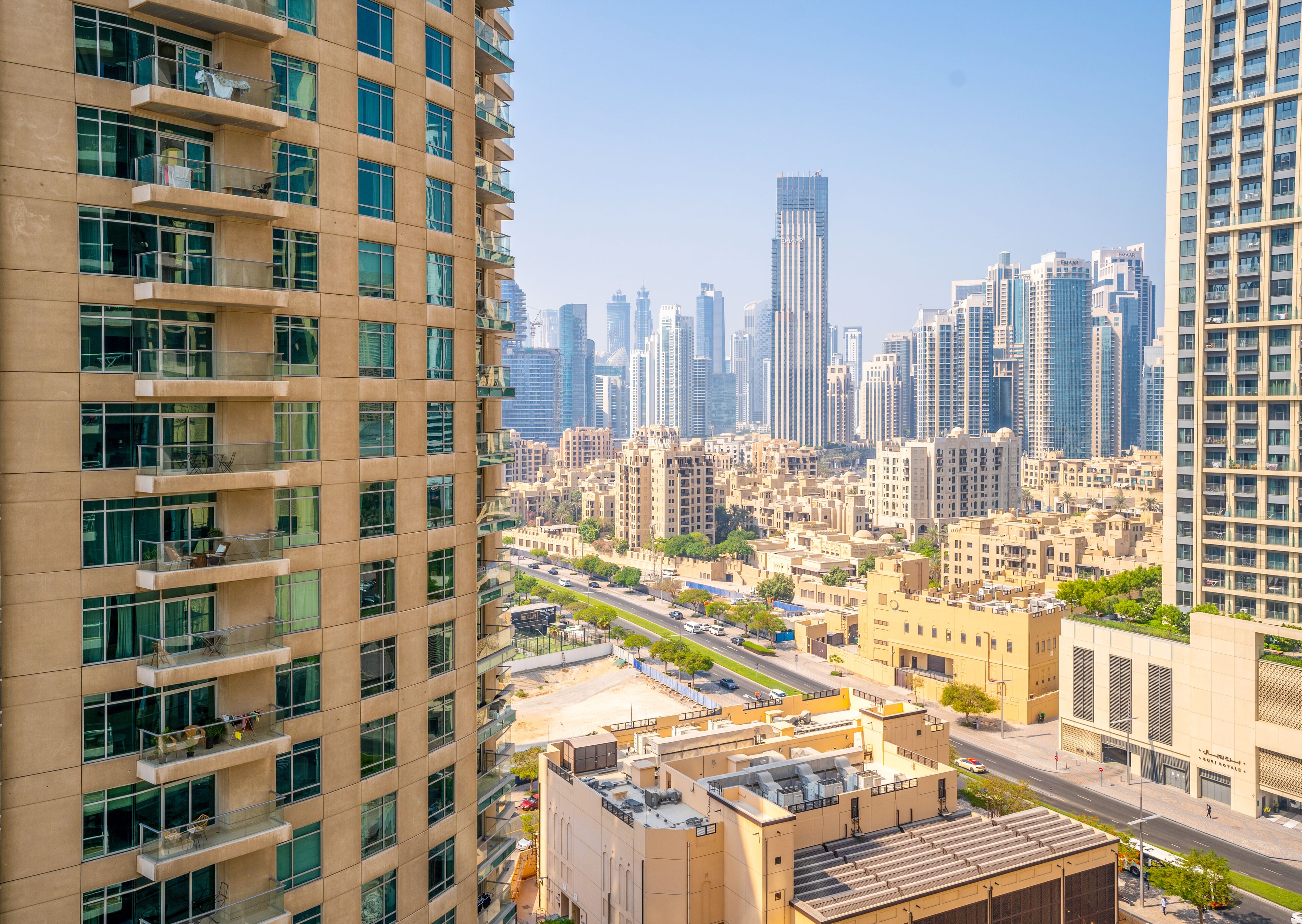 Un immeuble de grande hauteur doté de nombreux balcons et offrant une vue sur un paysage urbain composé de différents autres bâtiments.