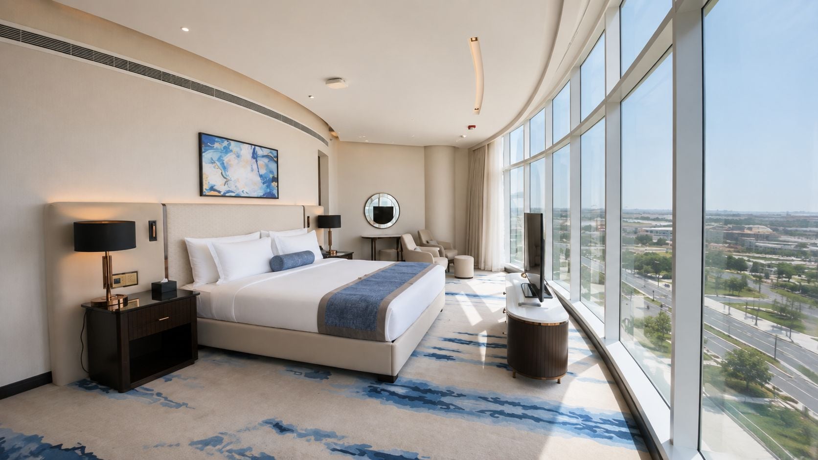 Quarto de hotel moderno com uma cama grande, escrivaninha, televisão e vista para a cidade.