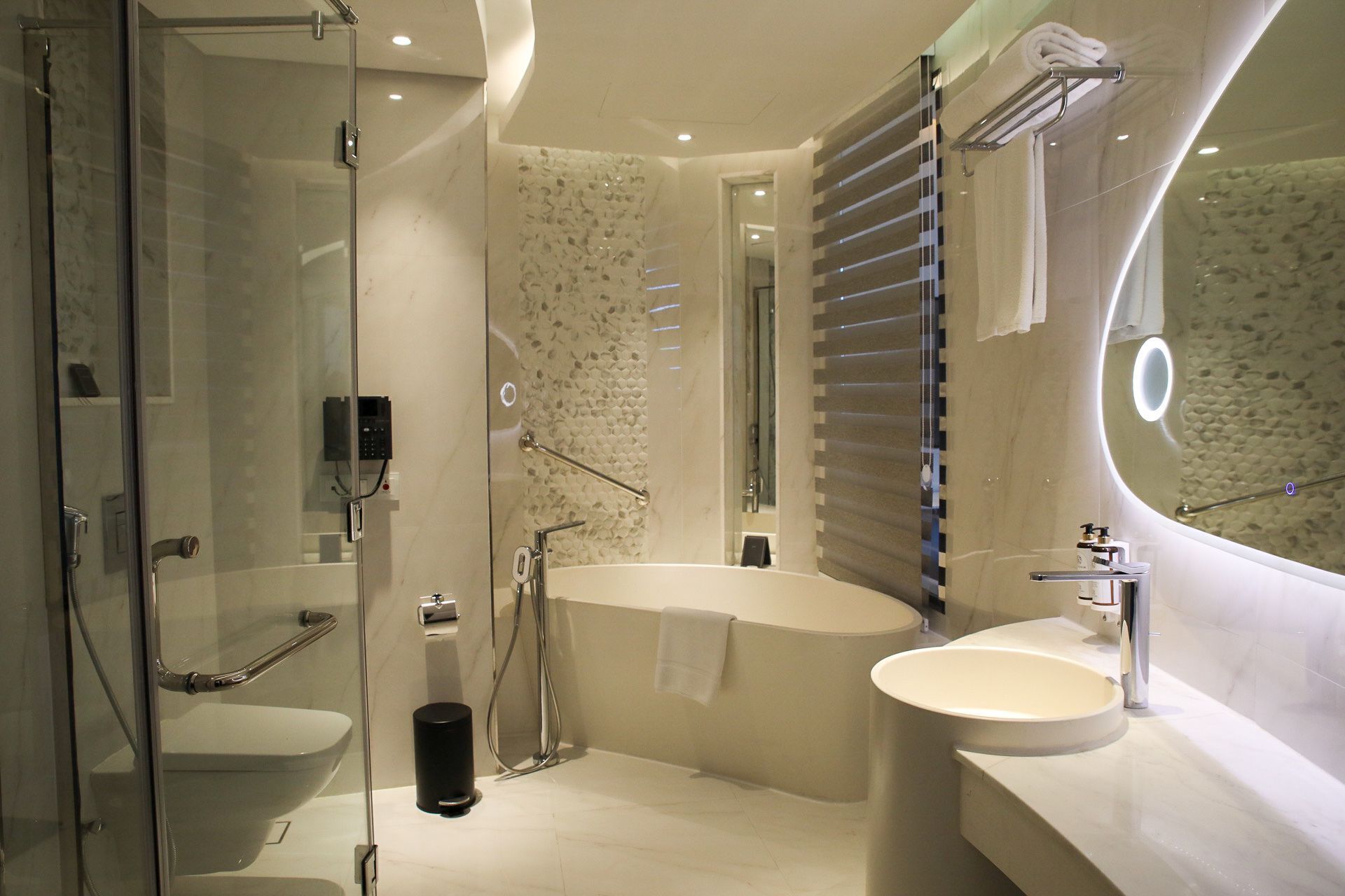 Ein modernes Badezimmer mit einer Duschkabine, einer freistehenden Badewanne und einem Waschtisch.