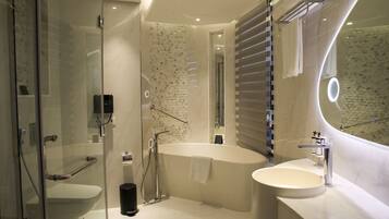 Ein modernes Badezimmer mit einer Duschkabine, einer freistehenden Badewanne und einem Waschtisch.