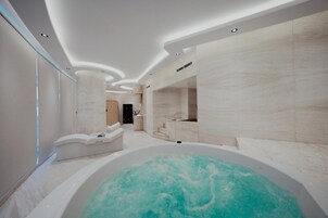 Een moderne spa met een ruime jacuzzi, een ontspanningsruimte en een receptie.