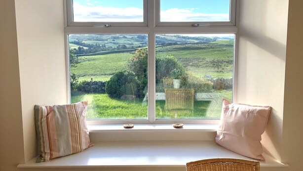 A room with a large window overlooking a green landscape. - Beautiful 5BR Rural Cottage with Outstanding Views - Pass the Keys (Castle Douglas)