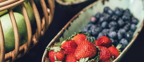 A close-up of a fruit bowl containing strawberries and blueberries.
