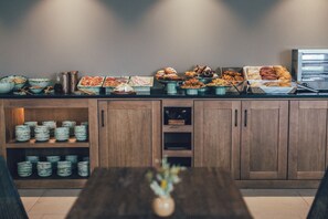 A buffet setup with various food items and a coffee machine. - Cala Lanuza Suites (El Campello)