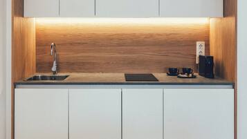 Una cocina moderna con armarios blancos, encimera de madera y un lavabo empotrado.