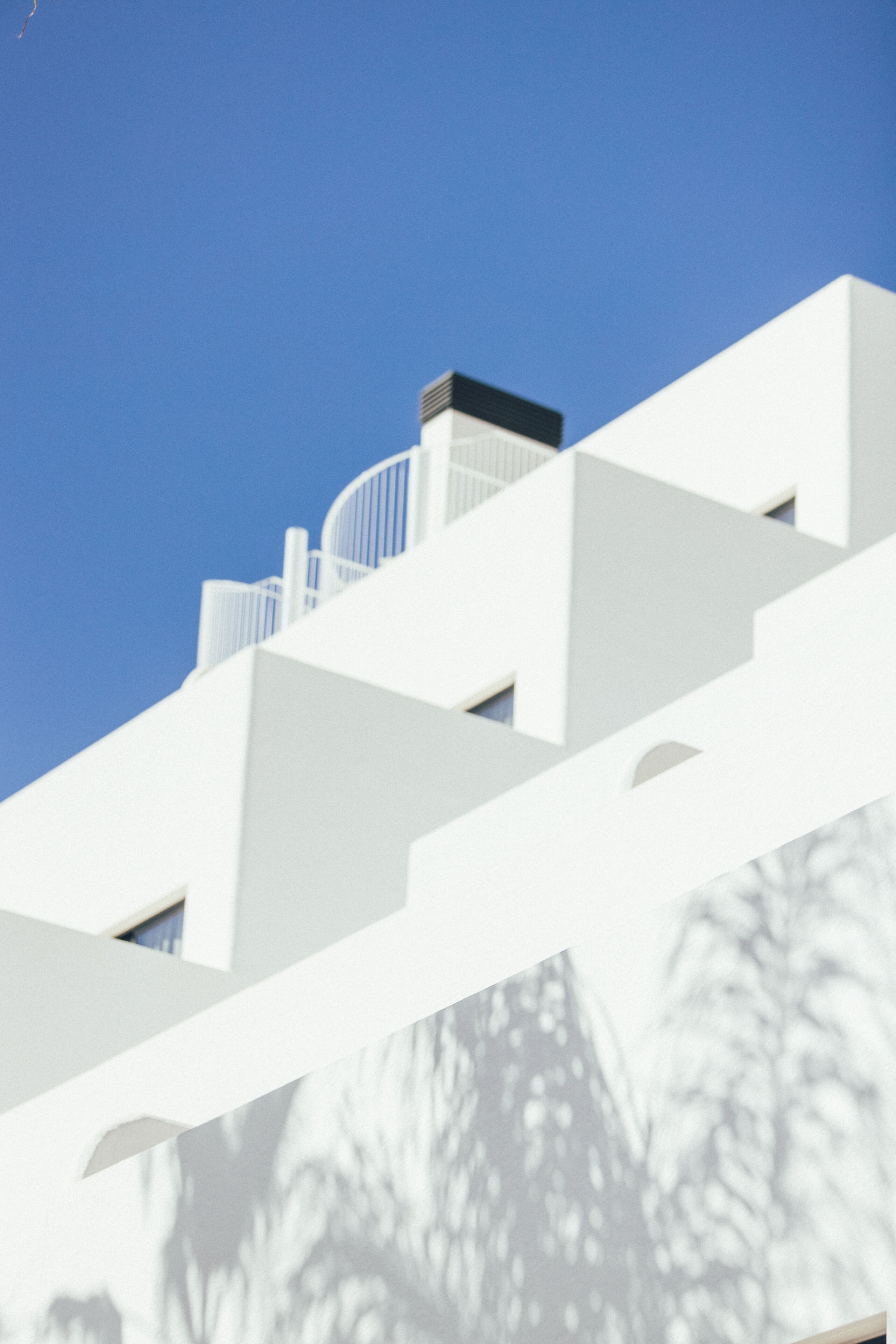 Un edificio moderno con fachada blanca y balcones.
