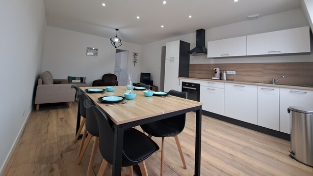 A modern kitchen with white cabinets, a wooden countertop, and a stainless steel sink.