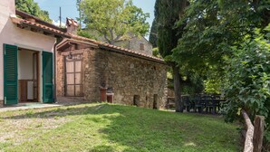 A stone building with a door and windows, a grassy yard, and a tree. - Agriturismo "Universal Harmony - Pettirosso" with Mountain View and Shared Pool (Dicomano)