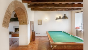 A pool table with a green felt surface, wooden beams, and a rustic brick archway. - Agriturismo "Universal Harmony - Pettirosso" with Mountain View and Shared Pool (Dicomano)