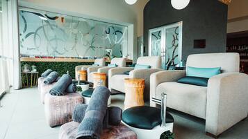 Unwind in a serene lounge area with plush armchairs and ottomans, featuring a striking abstract artwork.