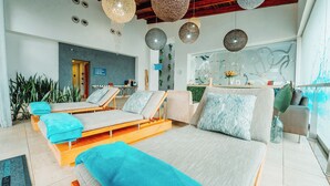 A modern spa room with a large bed, two lounge chairs, and a small seating area. - Silverstar Hotel  (Krugersdorp)