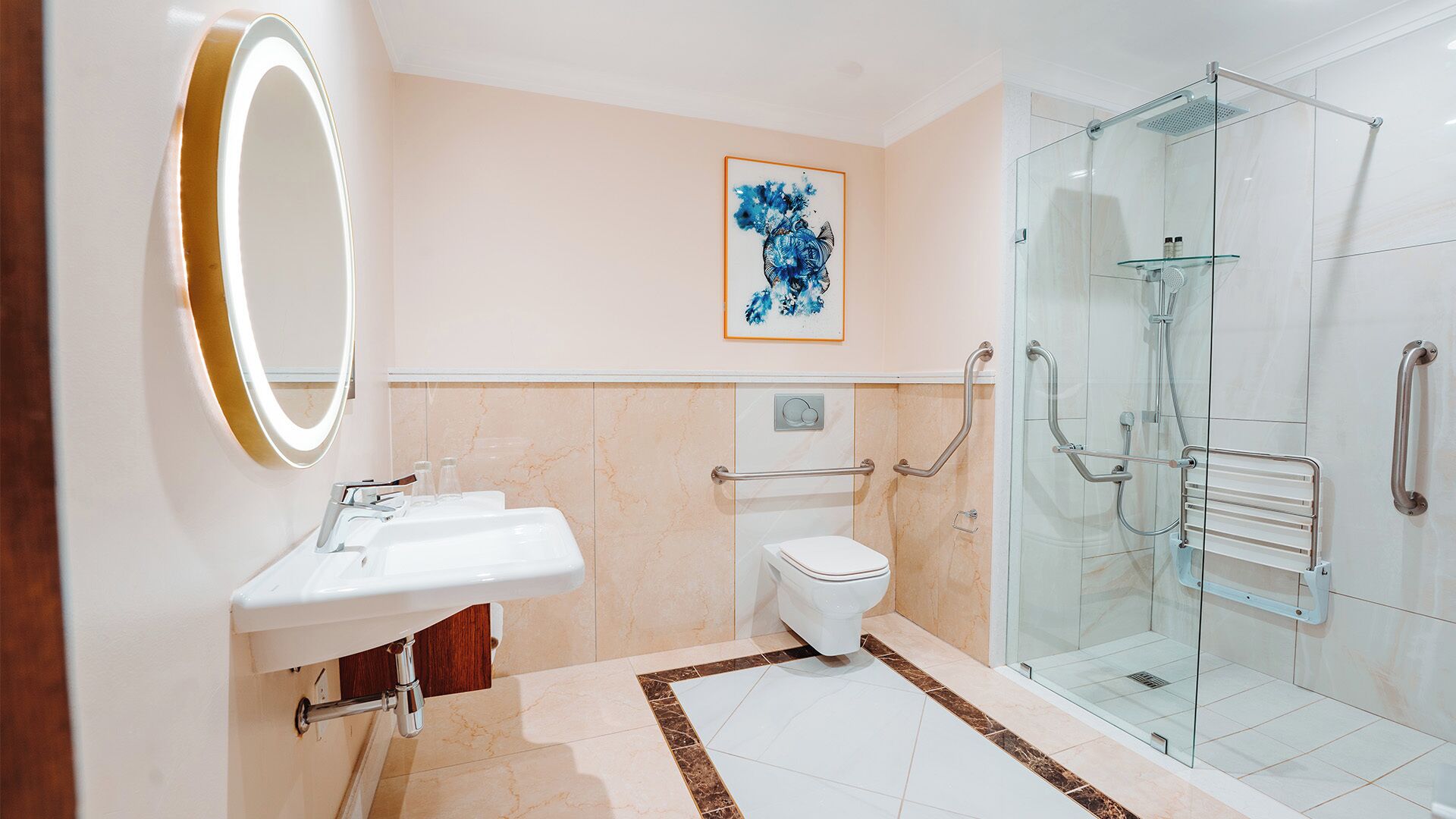 A modern bathroom with a glass shower, a white sink, and a toilet.