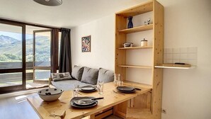 Una cucina moderna con un tavolo di legno apparecchiato per consumare i pasti, una libreria a incasso e vista sull'esterno.