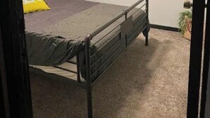 A bedroom with a bed, a nightstand, a lamp, and a wall-mounted hook. - Main St., Sturgis Rally Rental!! Enough Said!! (Sturgis)