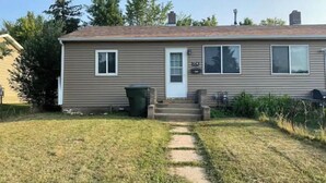 A single-story house with a front door, two windows, and a small front yard with a path leading to the door. - Main St., Sturgis Rally Rental!! Enough Said!! (Sturgis)
