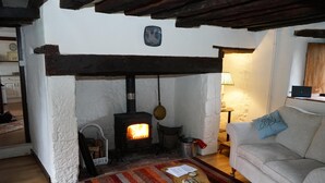 Una sala de estar acogedora con chimenea, un sofá y una mesita de centro.