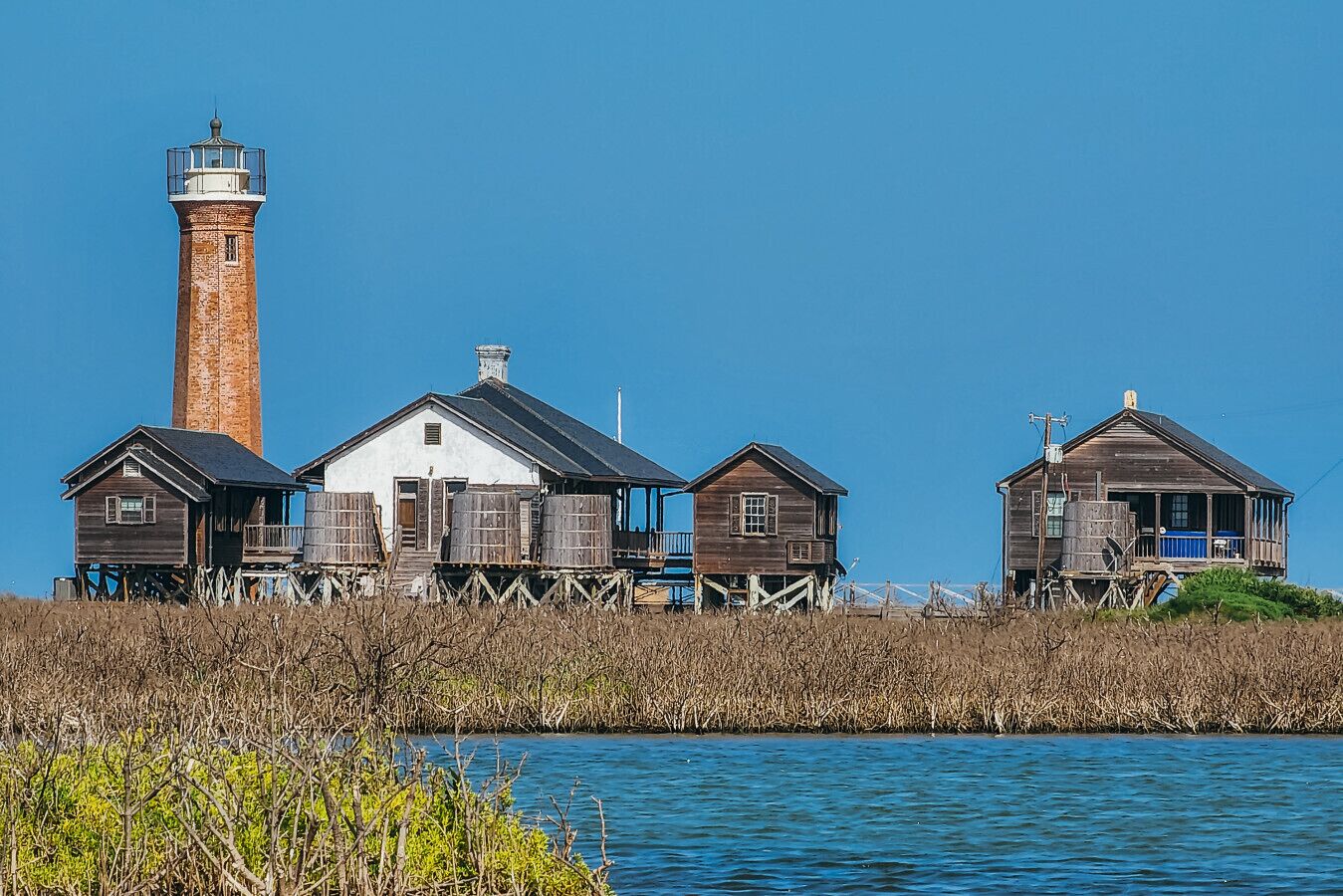 A picturesque coastal landmark where history meets the sea—iconic lighthouse views surrounded by charming waterfront cottages and endless blue skies.