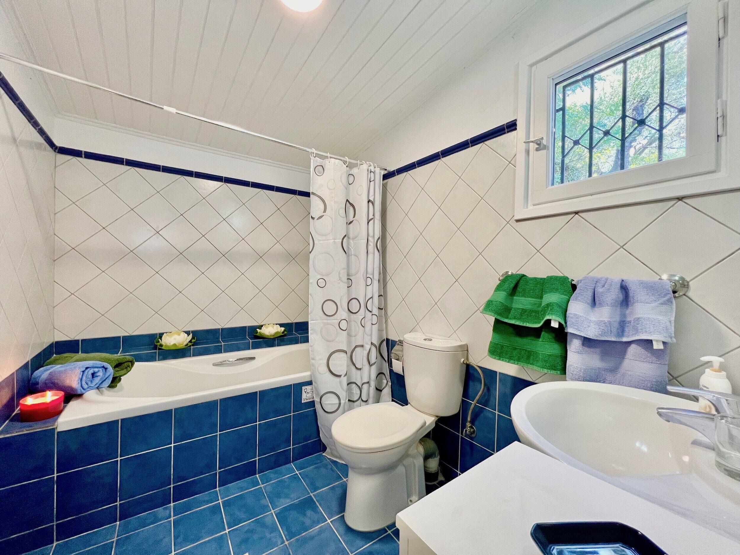 A bathroom with a bathtub, toilet, and sink.