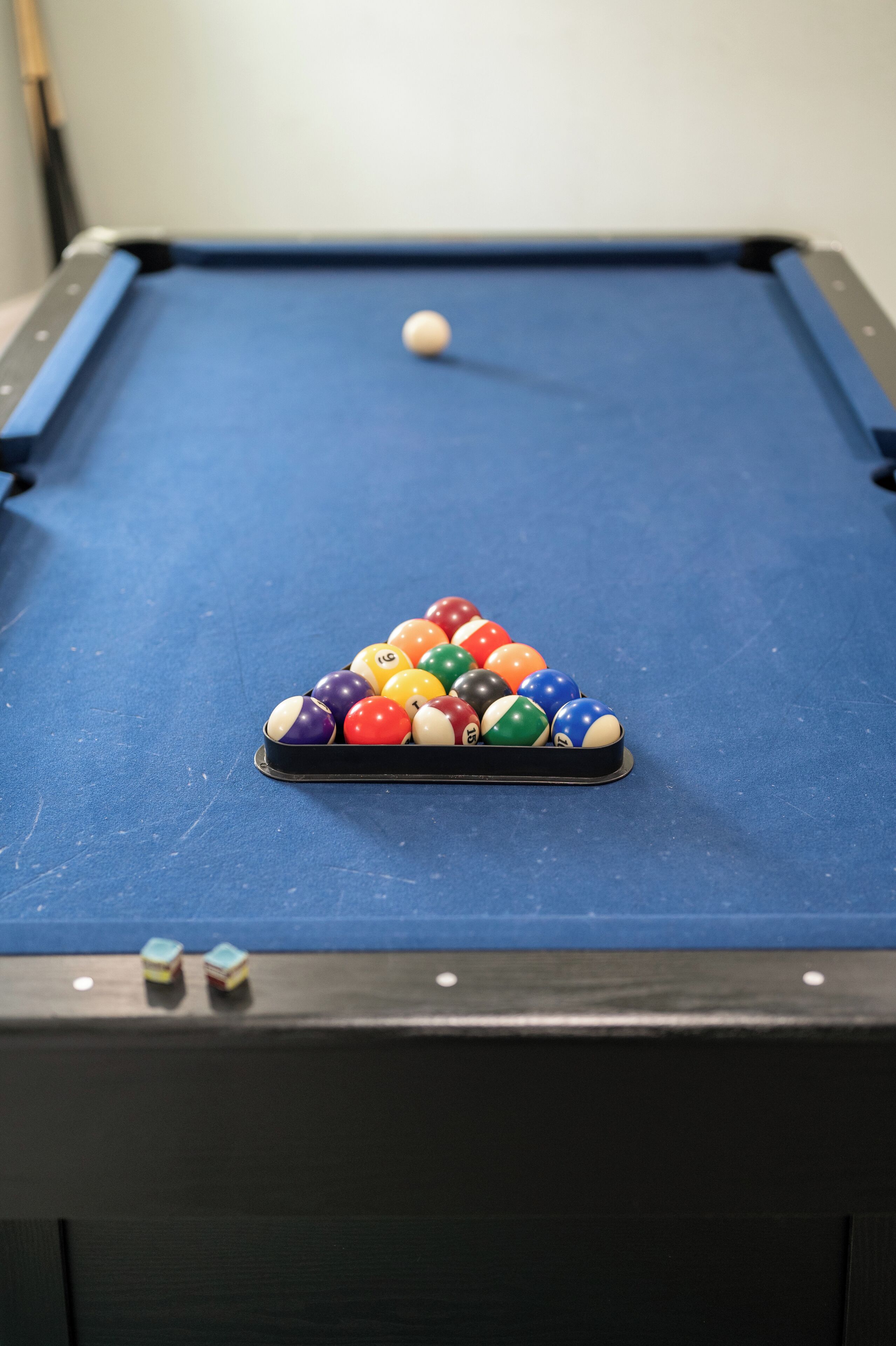 Ein Billardtisch mit einer dreieckigen Anordnung von Billardkugeln und einem im Schlag befindlichen Spielball.