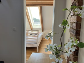A bedroom with a sloped ceiling, a wooden bed, and a skylight. - 85 m² Loft Apartment with Panoramic Views in Coburg (Coburg)