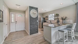 A modern kitchen with a central island, built-in appliances, and a decorative clock. - Greens View - Golf, 1 Block from the Strip! (Branson)