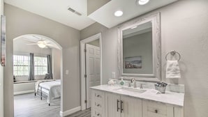 A bathroom with a large mirror, two sinks, and a vanity with drawers. - Greens View - Golf, 1 Block from the Strip! (Branson)