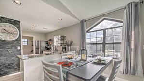 A modern kitchen with a central island, white cabinetry, and a large window providing natural light. - Greens View - Golf, 1 Block from the Strip! (Branson)
