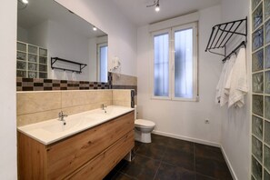 A bathroom with two sinks, a toilet, a mirror, and a window. - 5BR 3BTH · City Center · Quiet · Temporary Stay (Madrid)
