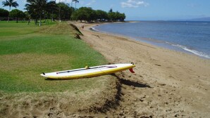 A beach with a surfboard lying on the sand near the water's edge. - Maui Sunset Vacation Rentals B206 (Kihei)