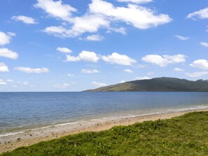Une plage avec un ciel dégagé et une eau calme.