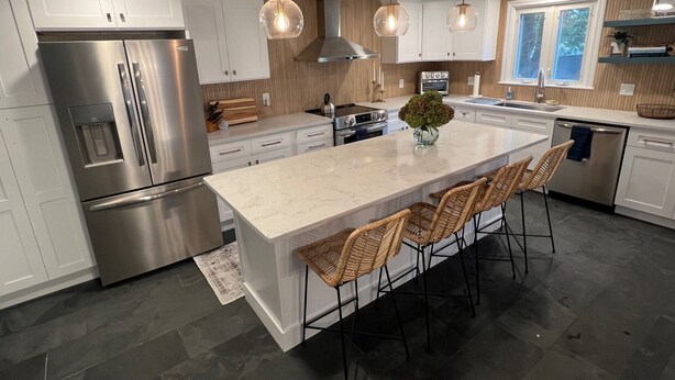 A modern kitchen with a large island, stainless steel appliances, and pendant lighting. - Cheerful, Newly Renovated Cottage close to Newport w/ hot tub! (MIddletown)