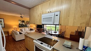 A compact kitchen with a built-in microwave, a stovetop, and a small countertop. - Oceanfront condo on wing of complex near beach, pool - Perfect for Sunsets (Kihei)