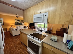A compact kitchen with a built-in microwave, a stovetop, and a small countertop.