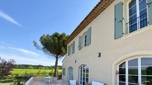 A spacious patio with outdoor furniture, a pergola, and a view of a lush landscape. - La Soleillade Aixoise (Aix-en-Provence)