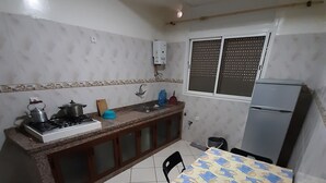 A compact kitchen with a gas stove, sink, and a refrigerator.