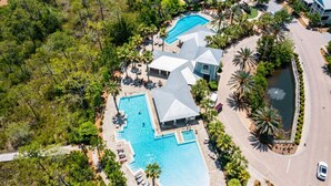 An aerial view of a resort with multiple swimming pools, a large central pool, and a guest lounge area with sun loungers. - Beargrass. 4 Bedroom Newly Updated with 6-Seater Golf Cart & Bikes! (Santa Rosa Beach)