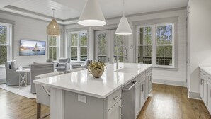 A spacious kitchen with a large island, white cabinetry, and pendant lighting. - Beargrass. 4 Bedroom Newly Updated with 6-Seater Golf Cart & Bikes! (Santa Rosa Beach)