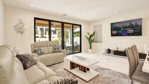 A modern living room with a sofa, coffee table, and TV.