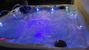 A hot tub with blue lighting and a person standing inside. - Springfed Canal on Lake George/ Large 4 Bedroom house on water/Boat Ramp/Hot Tub (SaltSprings)
