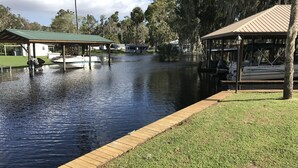 A canal with boats, wooden walkways, and covered structures. - Springfed Canal on Lake George/ Large 4 Bedroom house on water/Boat Ramp/Hot Tub (SaltSprings)